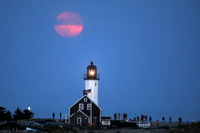 A Harvest Supermoon rises over a lighthouse in Scituate, Massachusetts, US