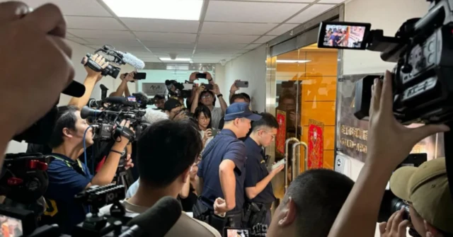 Media crowd around the door of the offices of Gold Apollo