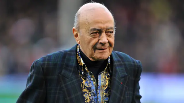 Mohamed Al Fayed, wearing a tartan-style jacket, smile and looks off to the right (file photo from 2013)