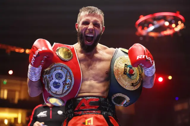 Anthony Cacace holds the IBO and IBF super-featherweight titles over his shoulders