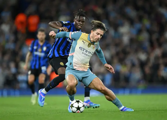 Jack Grealish of Manchester City runs with the ball under pressure from Yann Aurel Bisseck