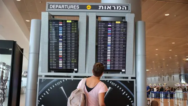 A woman looks at a departures board