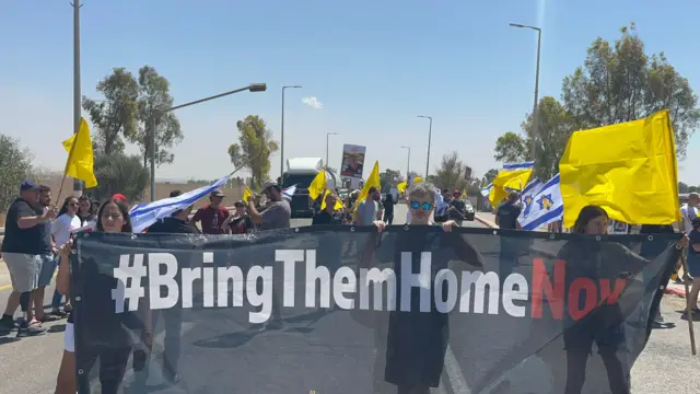 People hold up sign saying: Bring them Home