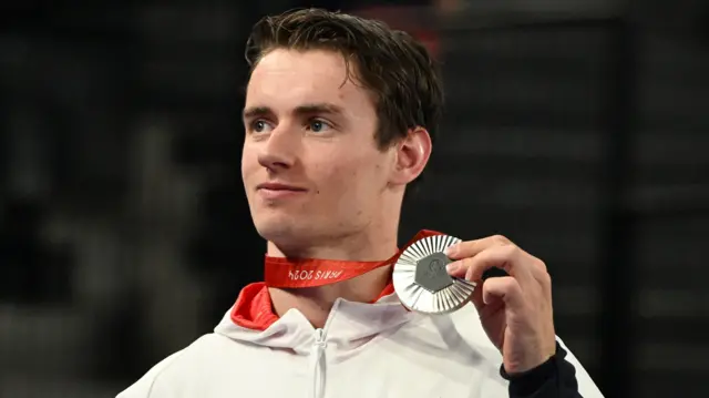 Dan Bethell holds his silver medal