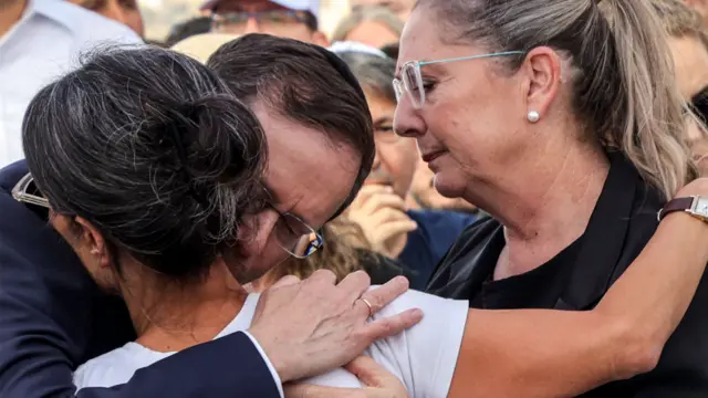 Israel's President Isaac Herzog and his Michal Herzog embrace Rachel Goldberg-Polin