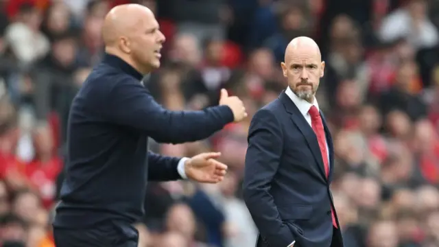 Erik ten Hag looks towards Arne Slot on the touchline at Old Trafford