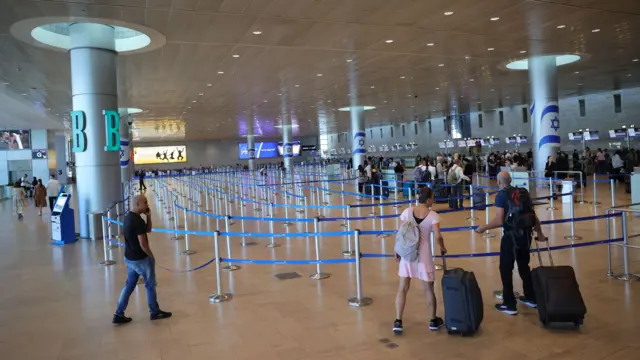 Passengers walk by an empty waiting area at the Ben Gurion International Airport