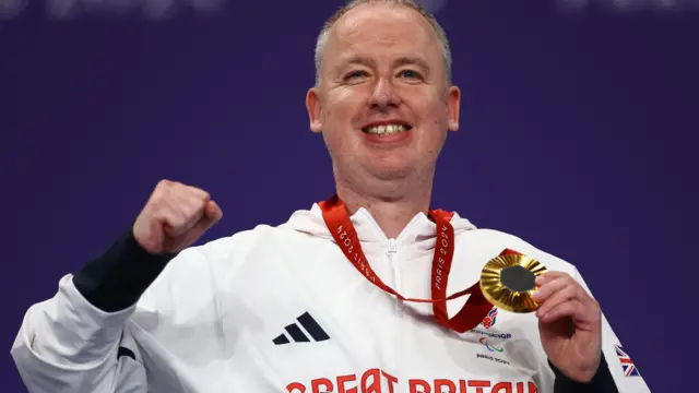 Stephen McGuire holds his gold medal