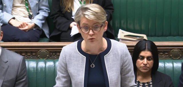 Yvette Cooper speaking in the House of Commons, she is wearing a grey jacket.