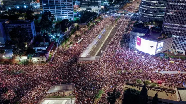 From above, a huge crowd gathers on a city intersection