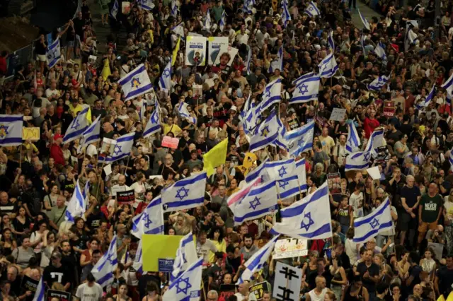 An overhead shot of a huge group of protesters waving yellow and Israeli flags