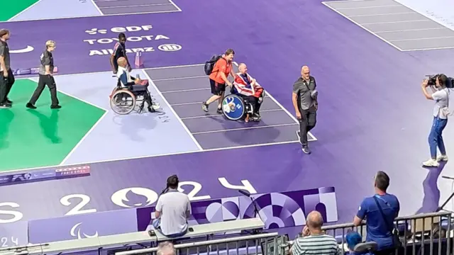 Stephen McGuire is wheeled away in the South Paris Arena in the Union flag