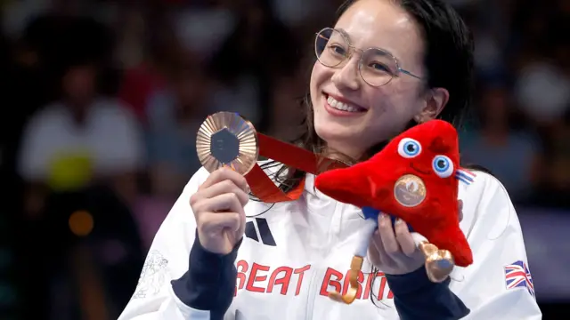 Alice Tai celebrates with a Paralympic medal