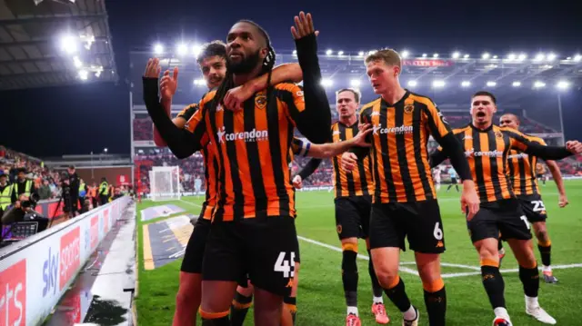 Kasey Palmer celebrates by the corner flag with his Hull teammates.