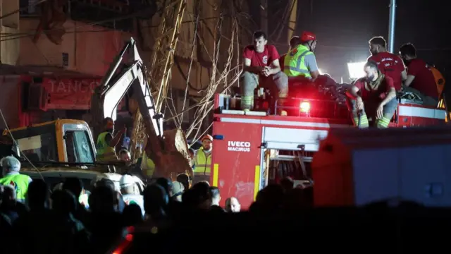 Emergency service workers on top of a service vehicle