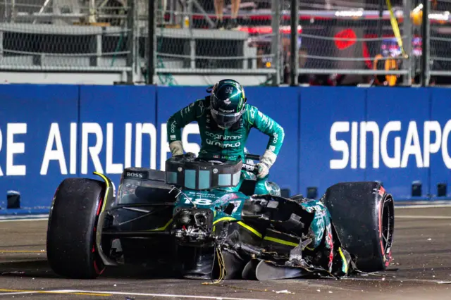 Lance Stroll climbs out of his Aston Martin after a crash