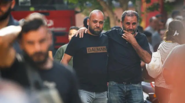 Two men crying near the scene of an Israeli strike on a Beirut suburb on 20 Fri Sept