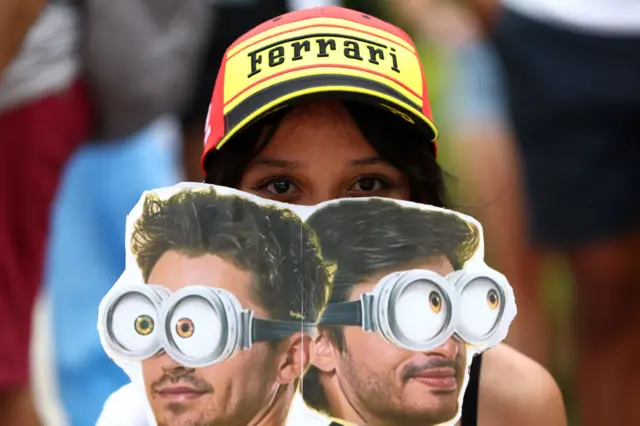 A Ferrari fan holds up a Charles Leclerc and Carlos Sainz sign