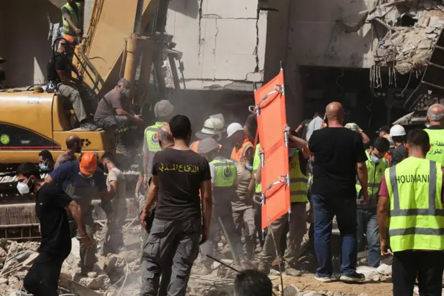 Group of medical staff at the site of an Israeli strike on a Beirut suburb on 20 Friday with one carrying a stretcher