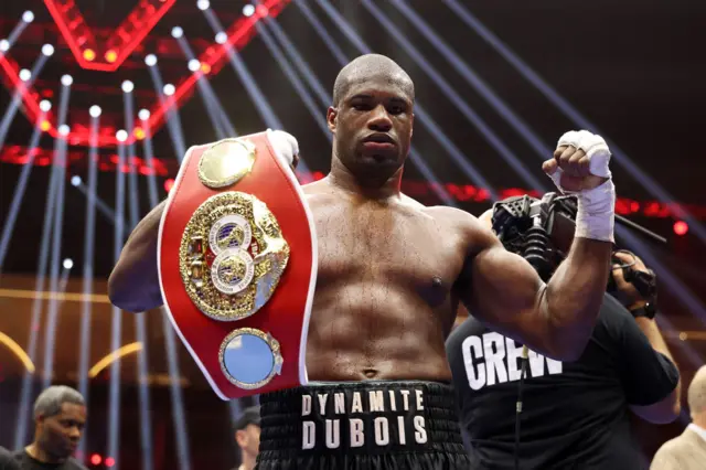 Daniel Dubois holds the IBF heavyweight title over his shoulder and raises his fist