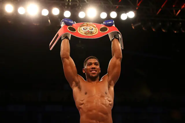 Anthony Joshua holds up his IBF title