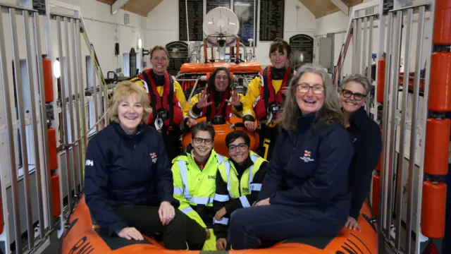 Volunteers sit in an RNLI lifeboat