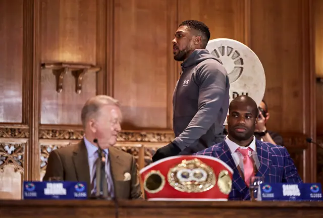 Anthony Joshua walks behind Frank Warren and Daniel Dubois