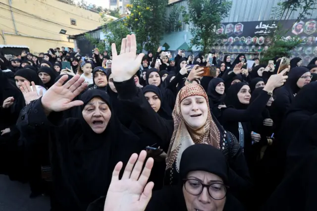 Women mourn on the day of the funeral of three Hezbollah members, who were killed during Israel's strike in Beirut on Friday