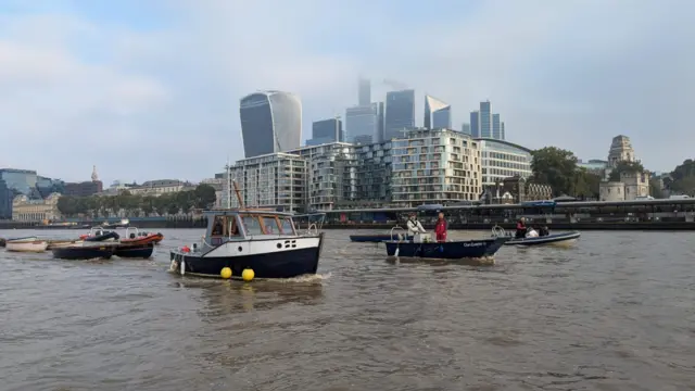 A number of boats seen against London landmarks including the 'Walkie Talkie' building