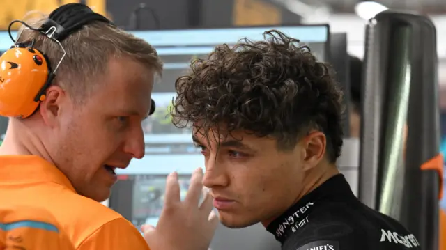 Lando Norris talking to a McLaren race engineer