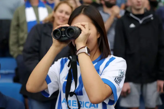 A Brighton fan looks through binoculars