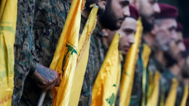 Hezbollah members seen holding flags at the funeral of  senior commander Ibrahim Aqil