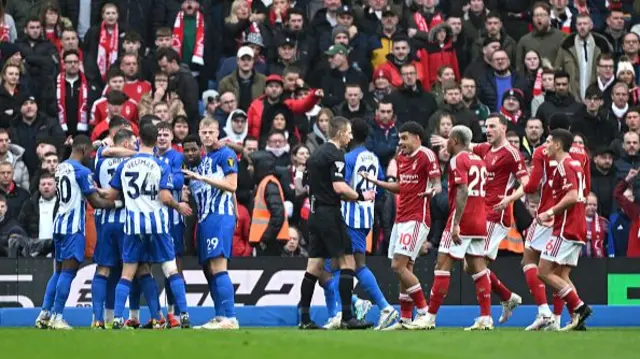 Morgan Gibbs-White of Nottingham Forest protests towards Referee Michael Salisbury with teammates as players of Brighton & Hove Albion celebrate after Andrew Omobamidele of Nottingham Forest (obscured) scores an own-goal