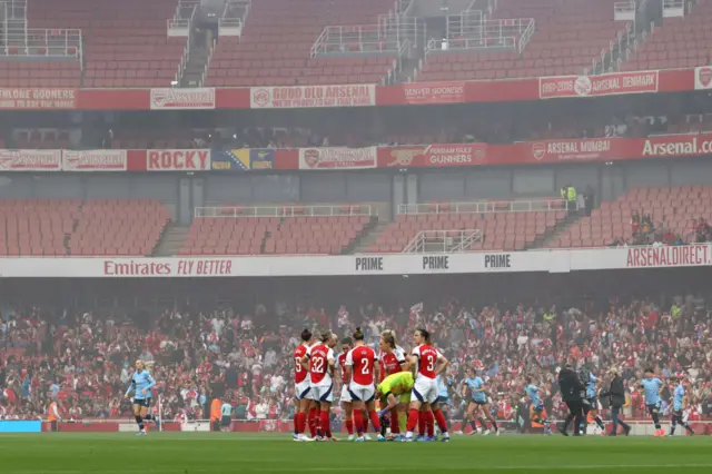 Players huddle on the pitch before kick off