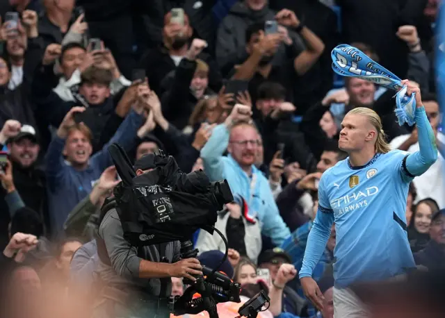 Haaland swinging a scarf in celebration