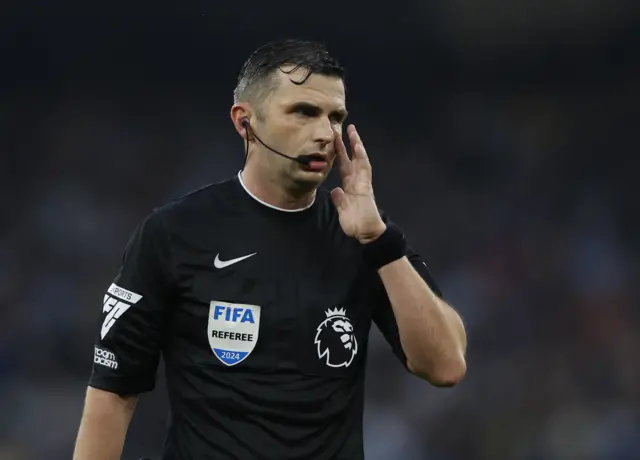 Michael Oliver holds his ear