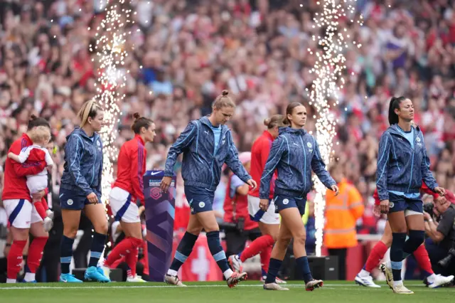 The players walk out onto the pitch