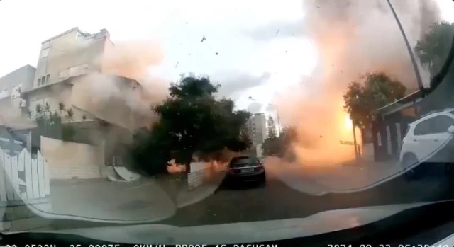 An rocket blast filmed from a dash camera on a stationary car