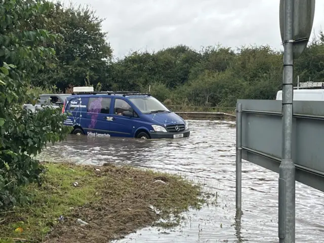 A blue van stopped in flood water at junction nine of the M1.