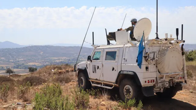 A white United Nations peacekeeping vehicle overlooking a valley