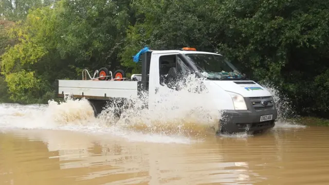 A van splashes through flood water on Hardwater Road near Wellingborough