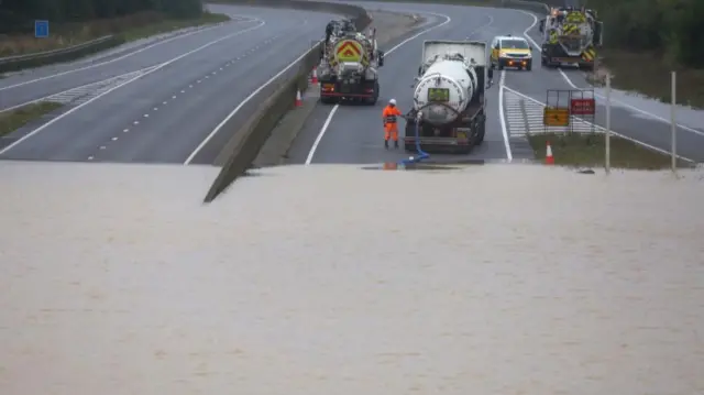 flood-water being pumped out from the A421, bedfordshire, England: Officials attempt to start pumping water from the A421 dual carriageway road after it was flooded following heavy rain, at Marston Moretaine near Bedford, Britain, September 23,