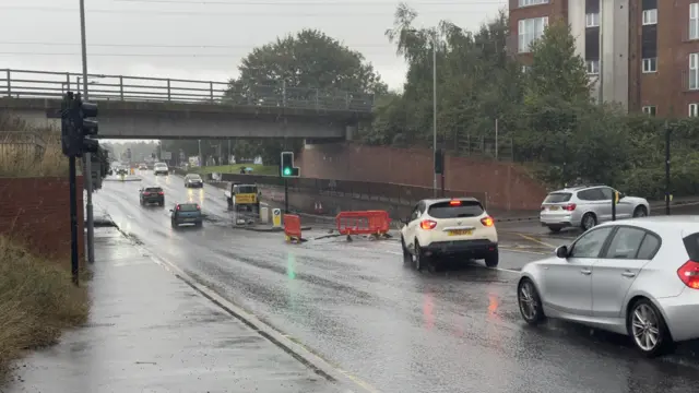 The scene at Duck Bridge in Dunstable the morning after the road under the bridge was flooded. Cars can be seen moving under the bridge and the road is clear of flood water. Some blockades remain in the middle of the road.