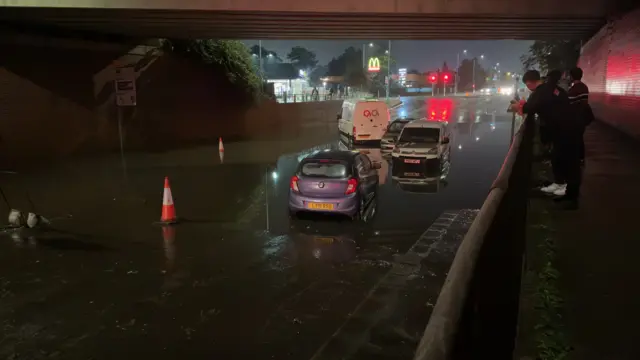 A photo shows flooding at Duck Bridge on Church Street in Dunstable. Several cars have been stranded in the flood water while several cones have been place under the bridge.