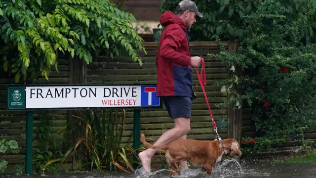 A man abandons his shoes in Willersley village, Gloucestershire, as he walks his dog. Photo: 23 September 2024