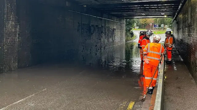 Water floods the road beneath a railway bridge in Hitchin, Hertfordshire