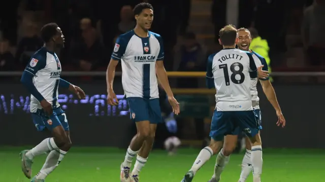 Morecambe goalscorer Hallam Hope celebrates with teammates.