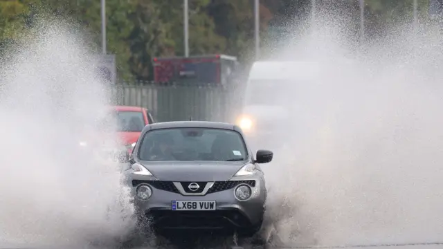 A car splashes through surface water in London after heavy rain. Photo: 23 September 2024