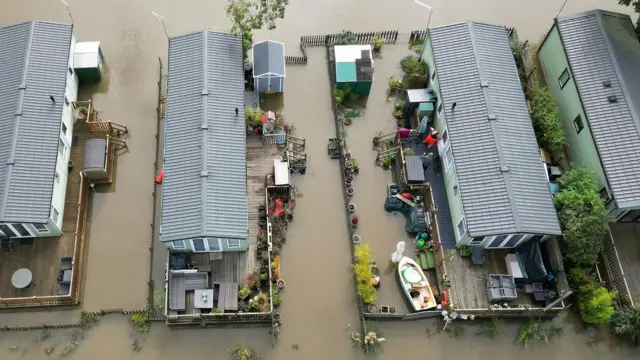 A view from a above shows gardens at the holiday park submerged in water.