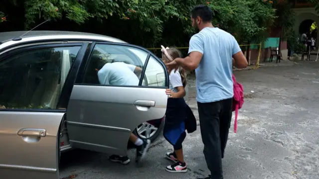 Children are pictured getting into a car